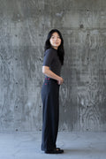 Model wearing The WUWEI Pant in charcoal, full side profile